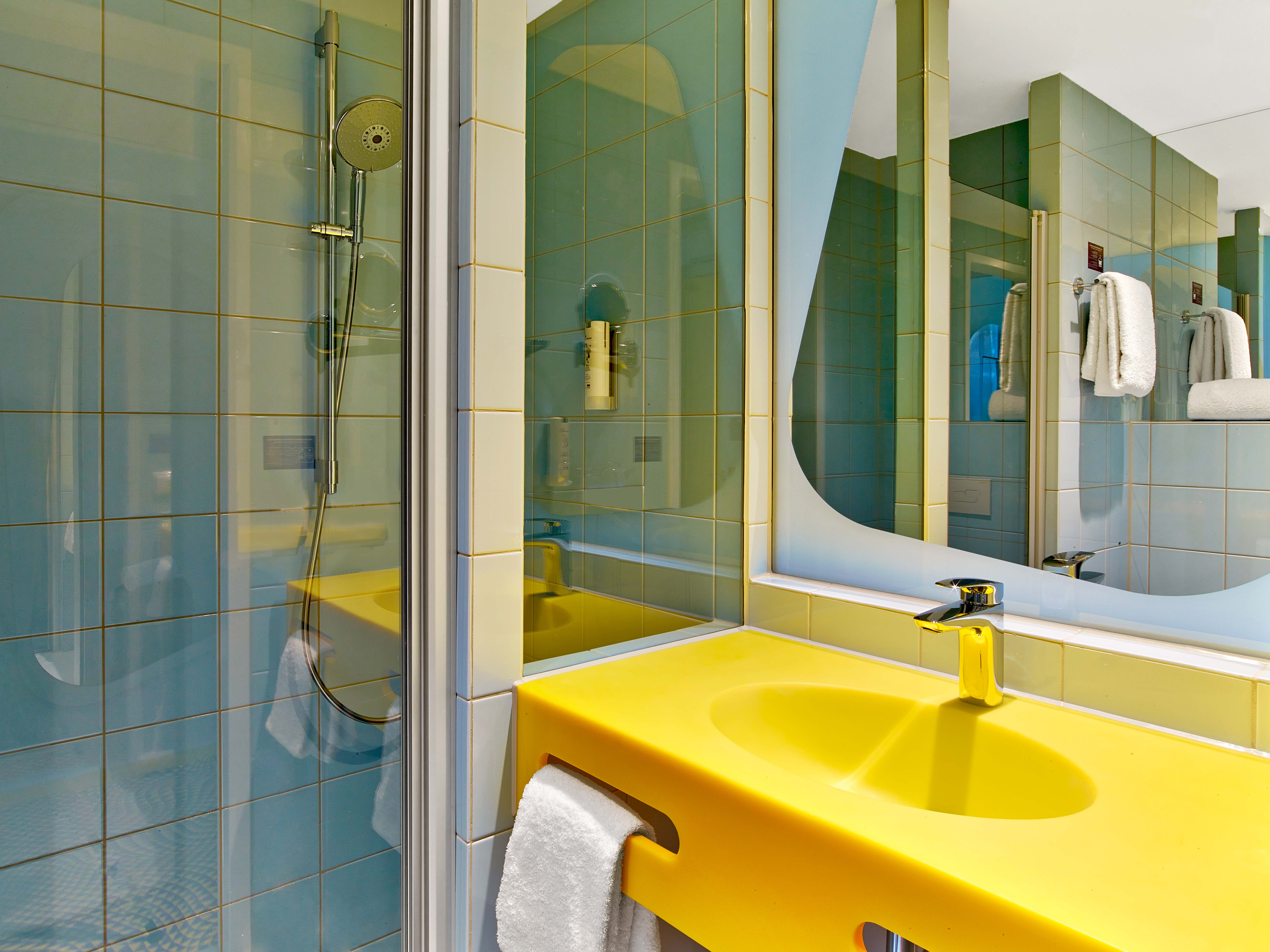 Ein geräumiges und modernes prizeotel Bad in gelber Farbe